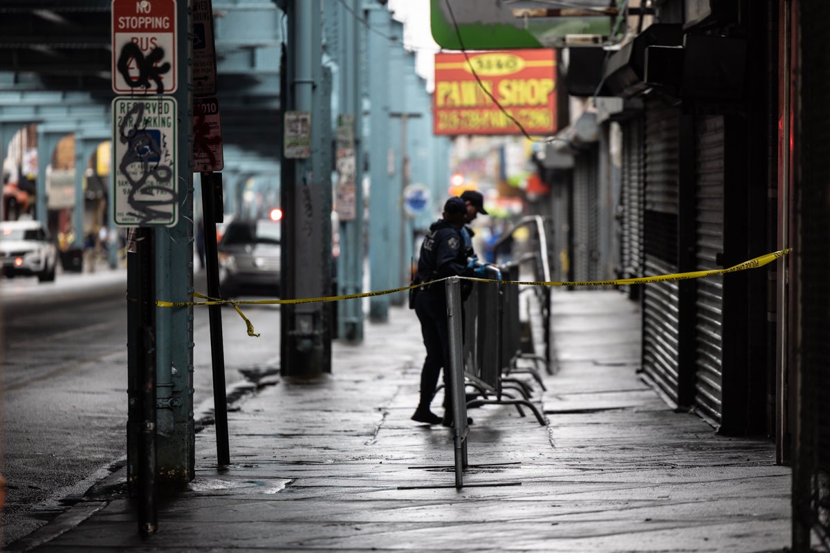 Police officers putting up barricades along the sidewalk