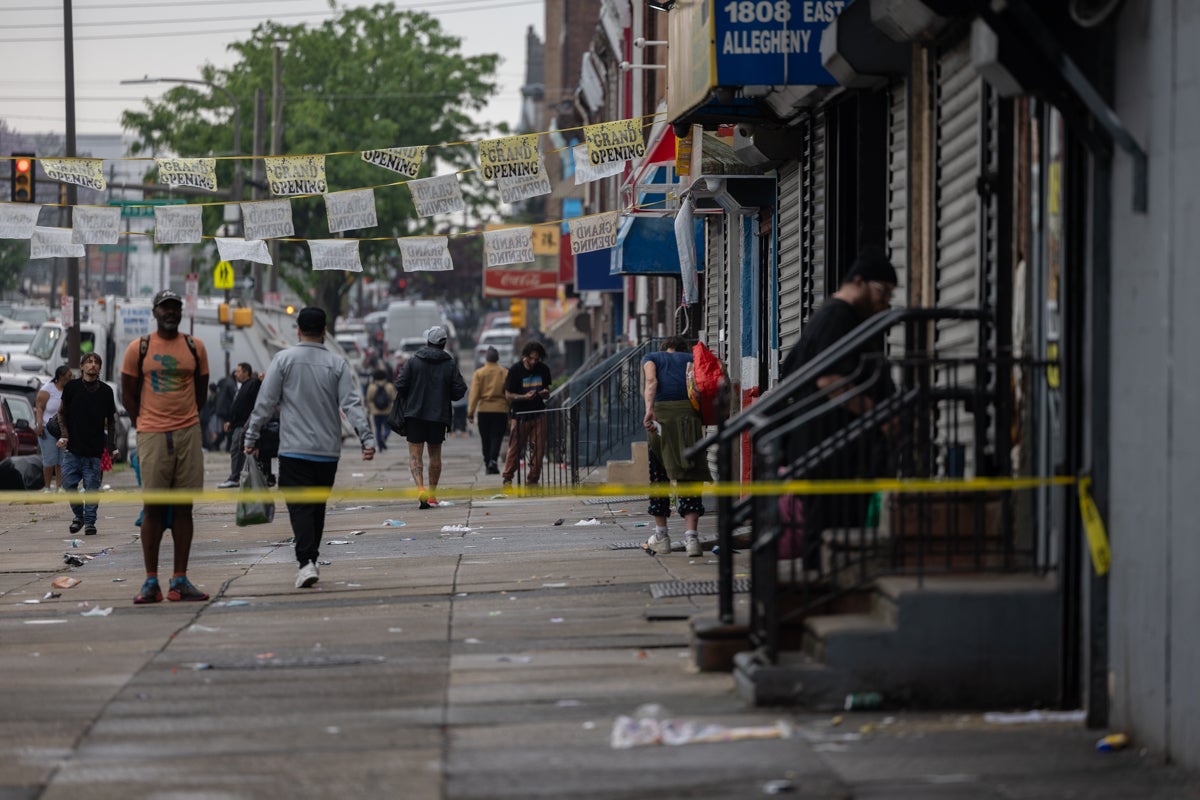 Many people standing on the sidewalk after the encampment had been cleaned up