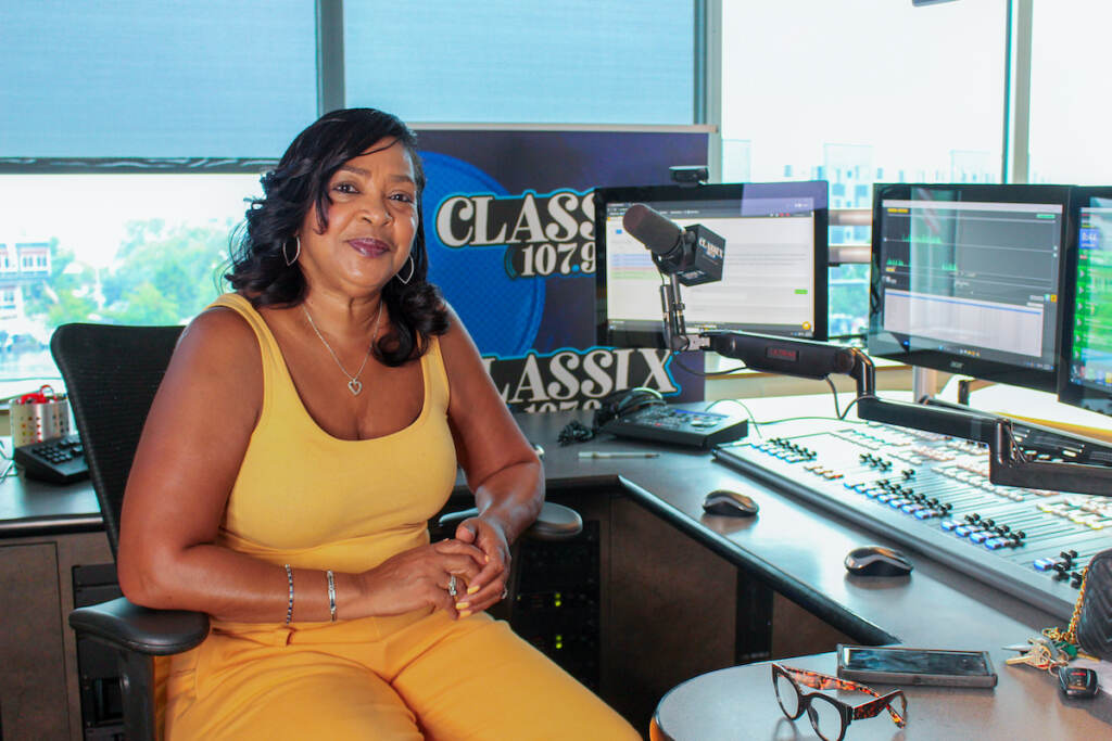 Lady B at her studio, posing next to a work station and a mic