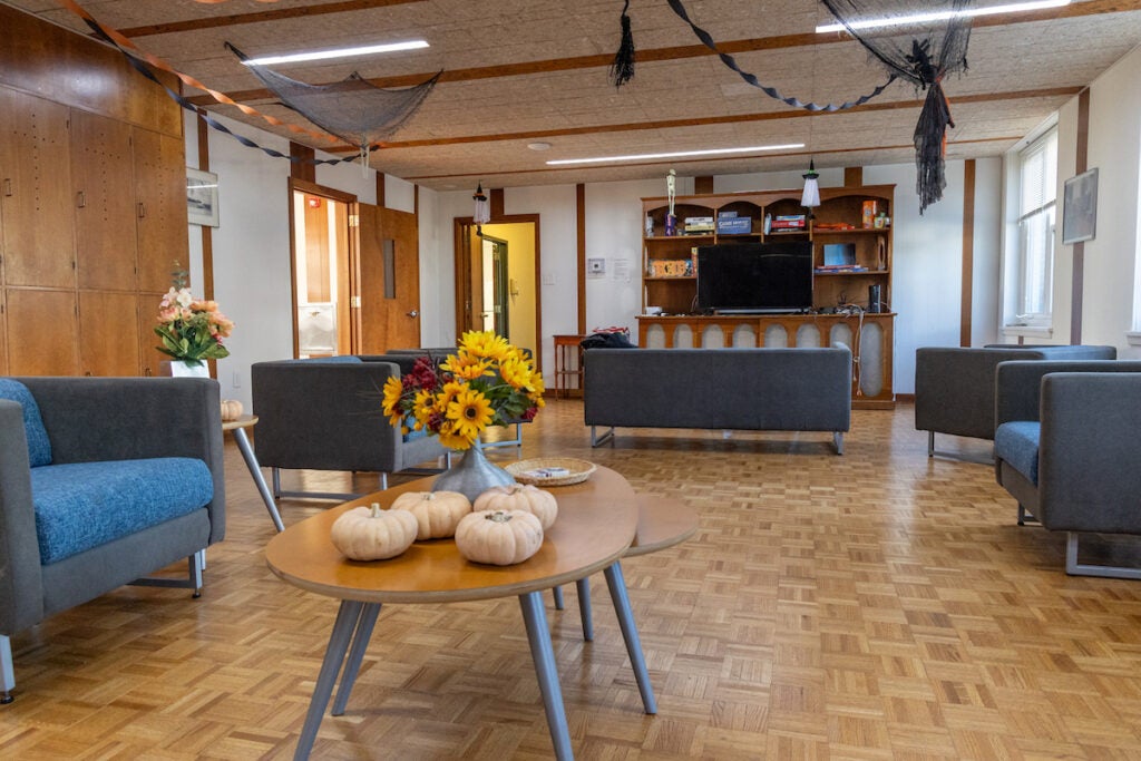 A common area and living room is decorated for Halloween.
