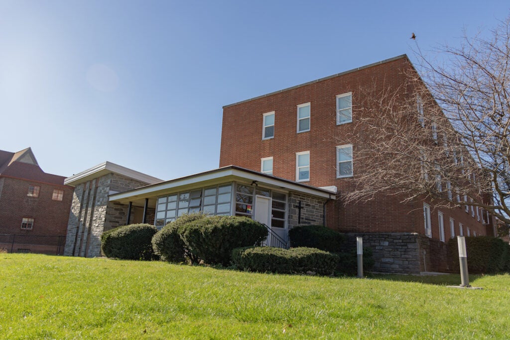A building by a green lawn on a sunny day.