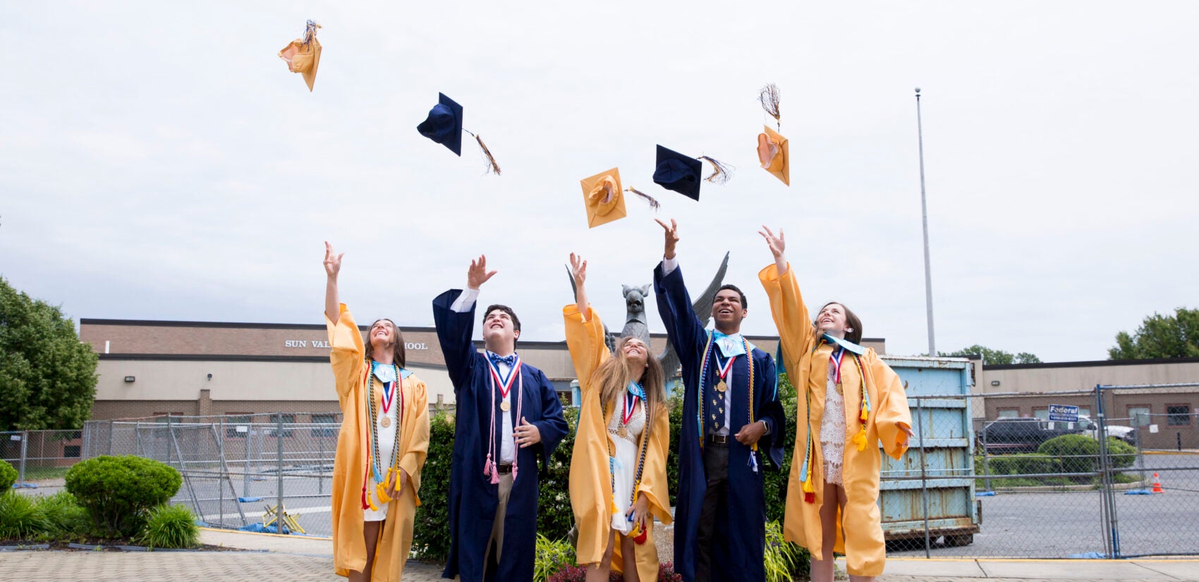 Bryson Eldridge (second to right), senior class president at his school, throws his graduation cap with other class officers after a segment they recorded for virtual graduation. Sun Valley High, in the Penn-Delco School District, is about 80% white.  (Rachel Wisniewski for Keystone Crossroads)
