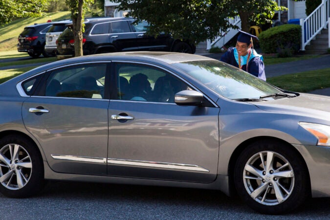 Bryson greets a guest at his drive by graduation party on June 9, 2020. (Rachel Wisniewski for Keystone Crossroads)