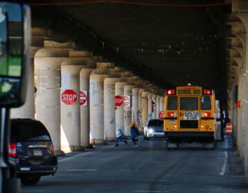 Children get off their school bus below the 25th Street Viaduct