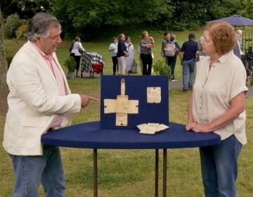 Joel Bohy appraising the artifacts next to Nanette Osborne