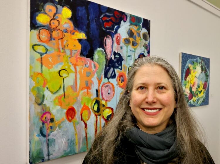 Erin Elman smiles next to her painting