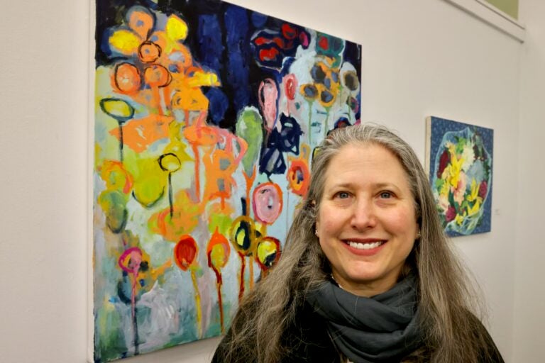 Erin Elman smiles next to her painting