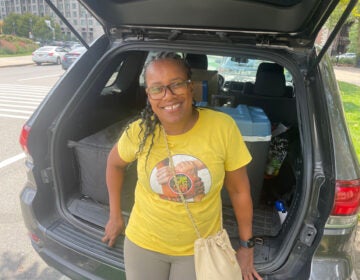 Angela smiling by a car