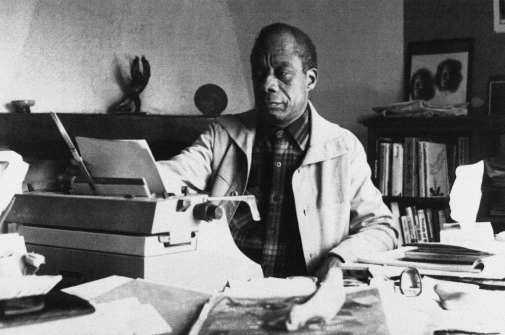 James Baldwin sits at a typewriter
