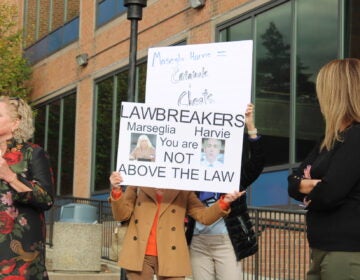 Republicans hold signs condemning commissioners