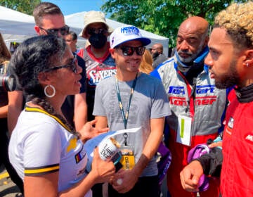 NASCAR driver Kyle Larson, center, talks with members of the Urban Youth Racing School before the start of a race on the grounds of the Please Touch Museum in Philadelphia, Friday, July 22, 2022.