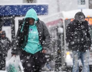 People walk during a winter snow storm in Philadelphia, Tuesday, Feb. 13, 2024.