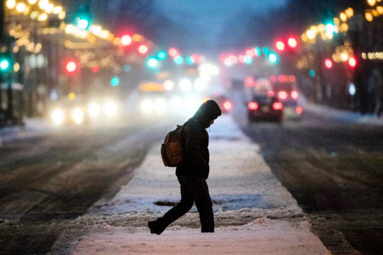 A person crosses South Broad Street during a winter storm in Philadelphia