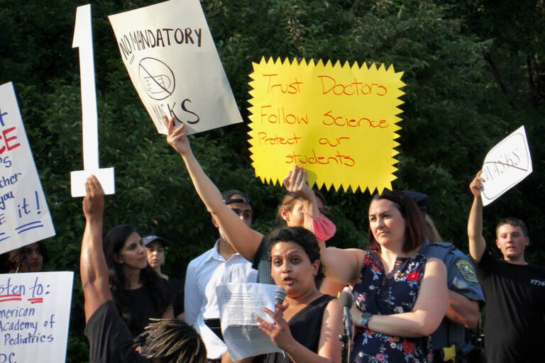 Anusha Viswanathan, July 27, 2021, speaking at a press conference in support of stricter COVID-19 safety policies, as other Central Bucks parents in the crowd shouted over her. (Emma Lee/WHYY)