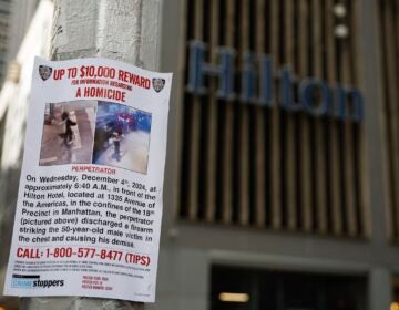 A Reward poster hung up on a light pole in front of the hotel