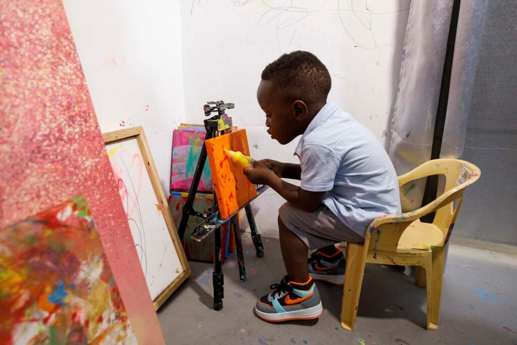 Ace-Liam Nana Sam Ankrah paints at his mother's art gallery in Accra, Ghana, May 27, 2024.
