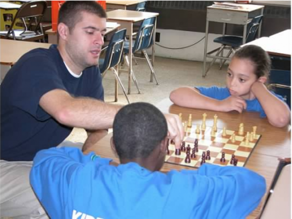 Marc Mannella teaches Zuleika Roman (right) chess in middle school. Zuleika was part of KIPP Philadelphia's first class in 2003. (Photo provided by KIPP Philadelphia Schools)